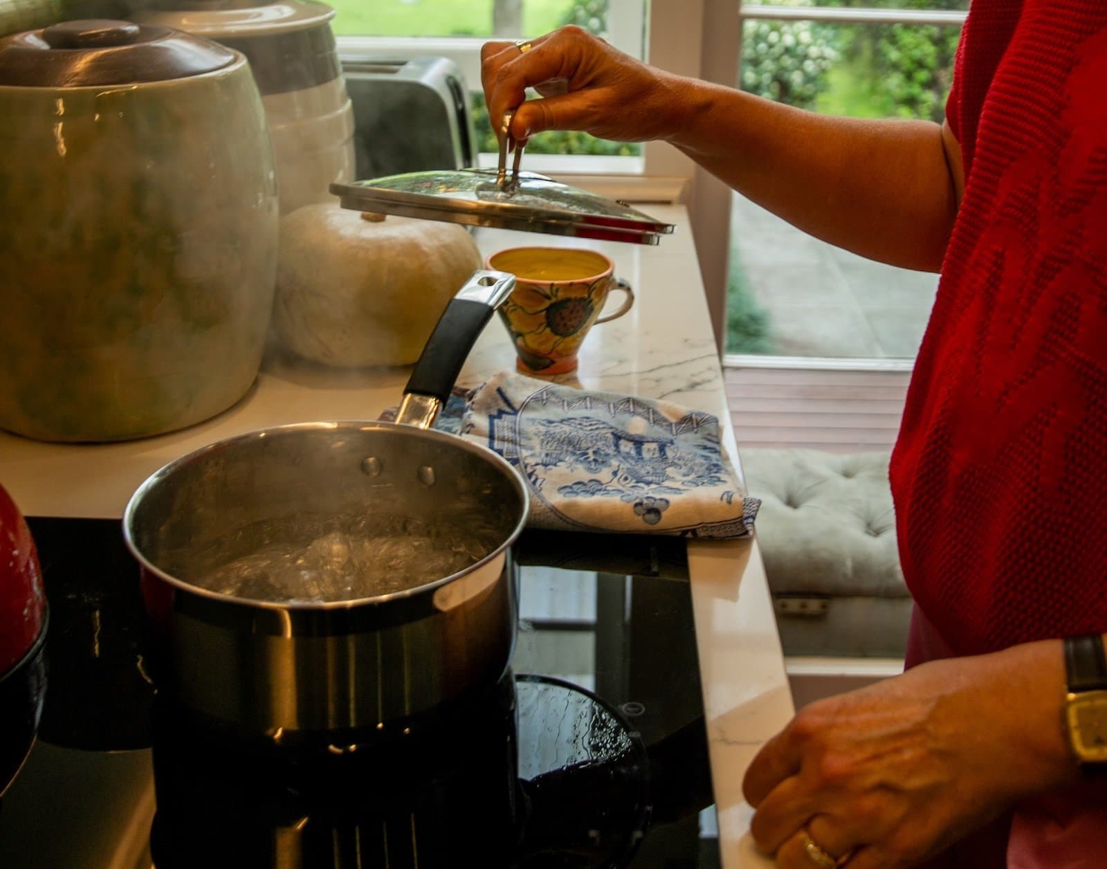 Hands adjusting the touch controls on an induction cooktop